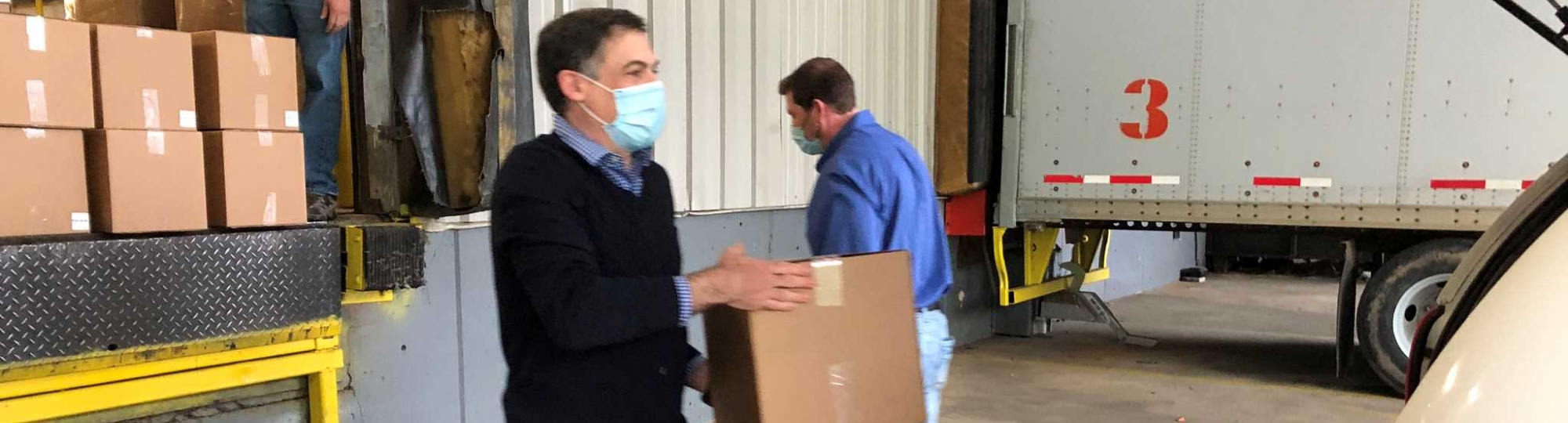 Jeff Slosman loads a box of wipes into a van for delivery